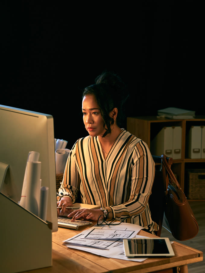Al lavoro sui documenti, a fine giornata, nella luce dello schermo